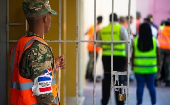 Military police monitor a voting center during national elections in the Dominican Republic in February. Credit: Brian Clark/Pact