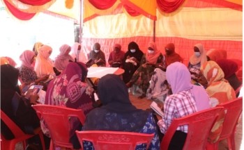 Women Peace Agents sit gathered in a tent in Sudan. Credit: Pact.