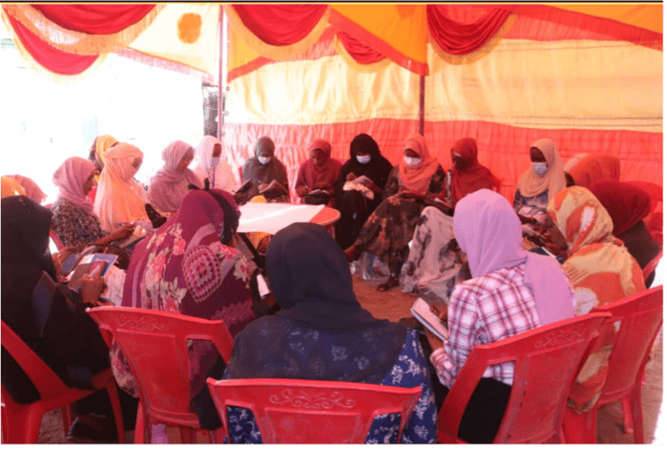 Women Peace Agents sit gathered in a tent in Sudan. Credit: Pact.